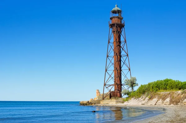 Farol velho na praia perto do mar . — Fotografia de Stock