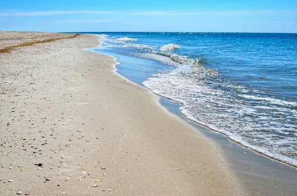 Κύματα της θάλασσας πλένονται καθαρή παραλία κατασκευασμένα από κελύφη. Τοπίο σε μια άγρια παραλία. — Φωτογραφία Αρχείου
