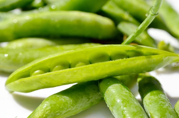 Schoten grüner Erbsen isoliert auf weißem Hintergrund — Stockfoto