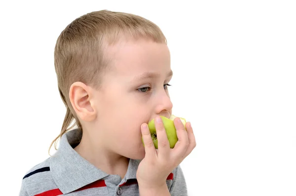 Niño comiendo una manzana sobre un fondo blanco — Foto de Stock