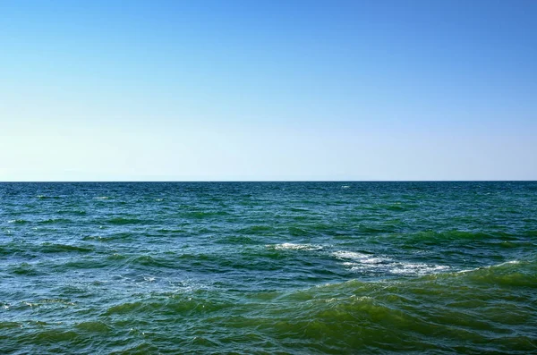 蓝色的天空映衬黑色大海的波涛。海景，在夏天的海 — 图库照片