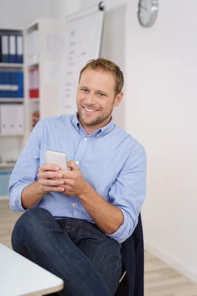 Friendly businessman checking his mobile phone — Stock Photo, Image