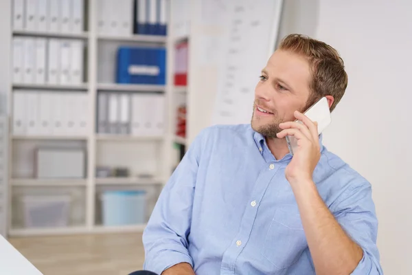 Uomo d'affari che parla su un cellulare in ufficio — Foto Stock