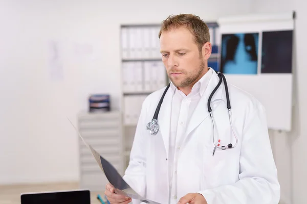 Doctor looking at an x-ray with concern — Stockfoto