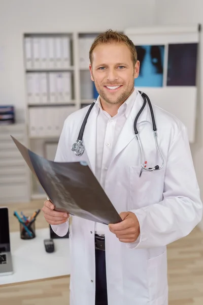 Lächelnder selbstbewusster Arzt mit einem Röntgenbild — Stockfoto
