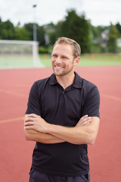 Vriendelijke Atletiek coach permanent met gevouwen armen — Stockfoto