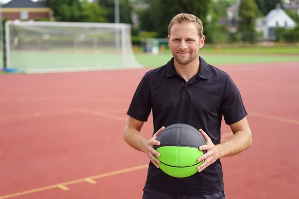 Lächelnder Mann mit Ball in Tornähe — Stockfoto