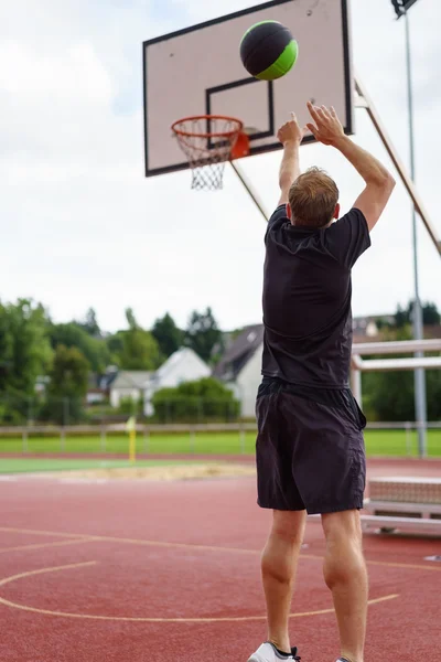 Mann übt seinen Basketball und zielt auf ein Tor — Stockfoto