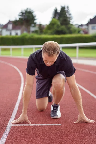 Athletic man on the starter grid on a race track — Stock Photo, Image