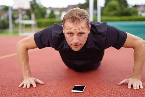 Man doet fitness oefeningen met behulp van een mobiele app — Stockfoto