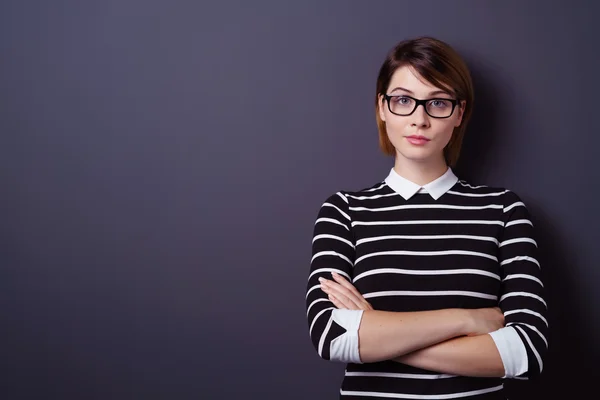 Cute young woman with folded arms leaning on wall — Φωτογραφία Αρχείου