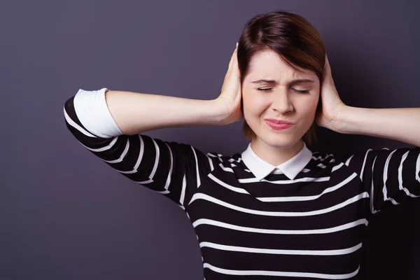 Annoyed woman covering ears with hands — Stock Photo, Image