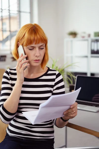 Concerned businesswoman discussing a document — Stockfoto