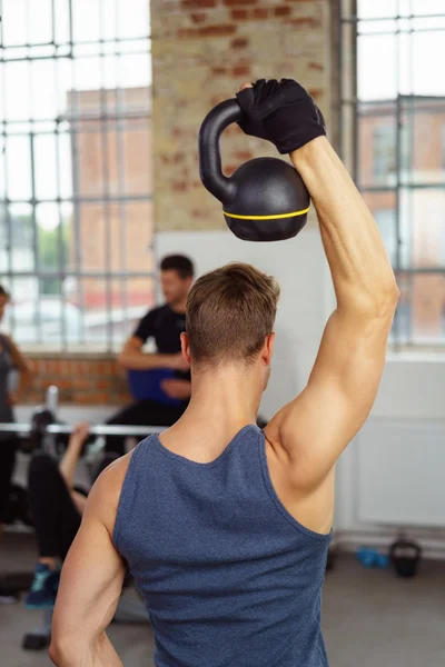 Man lifting kettle bell weight — Stockfoto