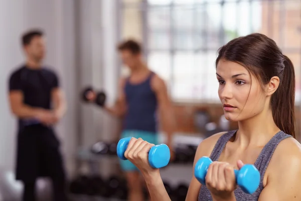 Serious woman doing bicep curls — Stock Photo, Image