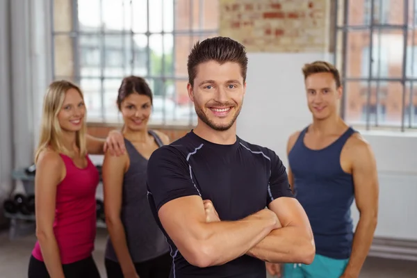 Athletic trainer standing with folded arms at gym — Stock Photo, Image