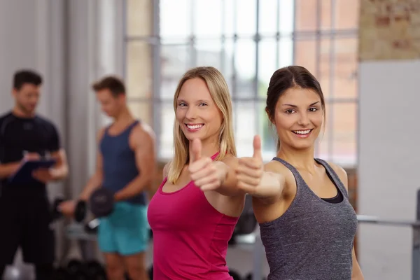 Pair of confident women athletes holding thumbs up — Stock Photo, Image
