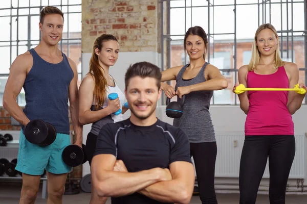 Four athletes behind man with folded arms — Stock Photo, Image