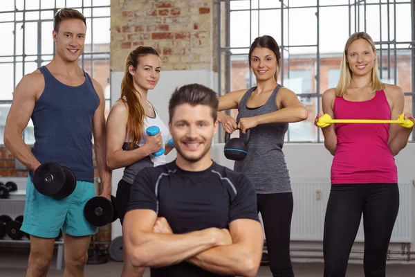 Four athletes behind man with folded arms — ストック写真