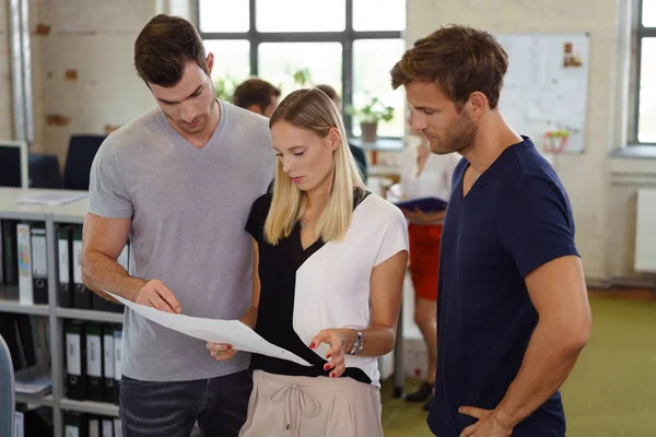 Three business colleagues discussing a document — Stock Photo, Image