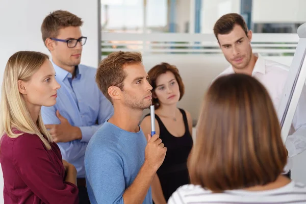 Group of adults watching man write on board — Stock Photo, Image