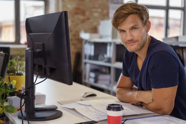 Handsome man with folded arms at work desk — Stock Photo, Image