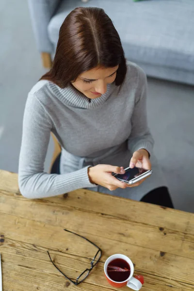 Junge Frau sitzt und schreibt eine Nachricht — Stockfoto