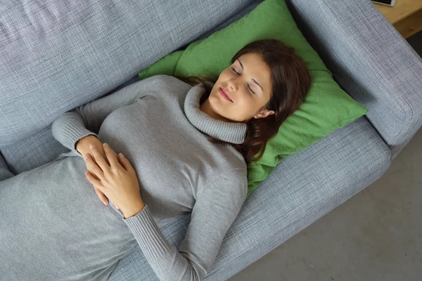 Yorgun genç kadın kanepede şekerleme — Stok fotoğraf