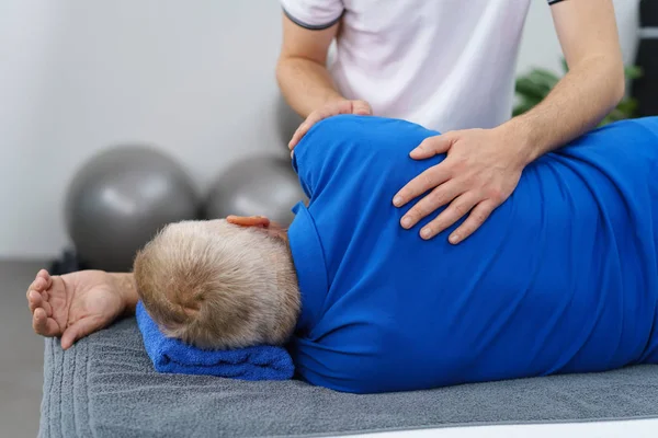 Fisioterapeuta examinando ombro de homem idoso — Fotografia de Stock