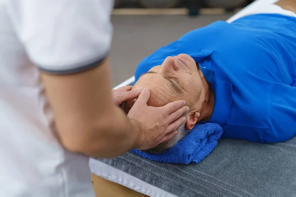 Fisioterapeuta dando masaje en la cabeza al paciente —  Fotos de Stock
