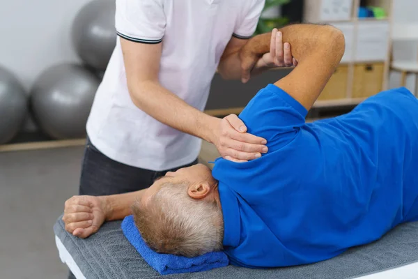 Fisioterapeuta haciendo masaje a anciano —  Fotos de Stock