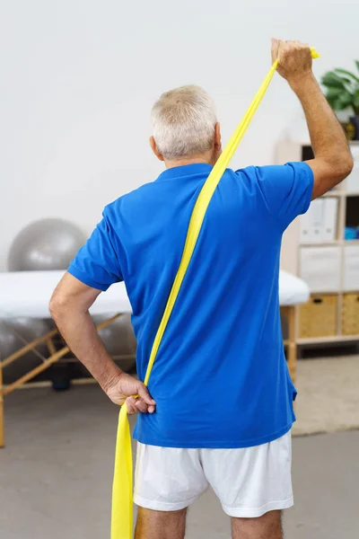 Äldre man stretching elastiskt band — Stockfoto