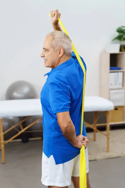 Äldre man stretching elastiskt band — Stockfoto
