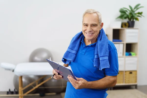 Elderly man holding clipboard — Stock Photo, Image