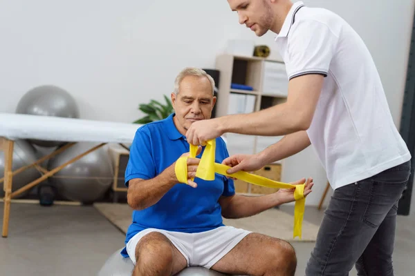 Trainer working out with retired man — Stock Photo, Image