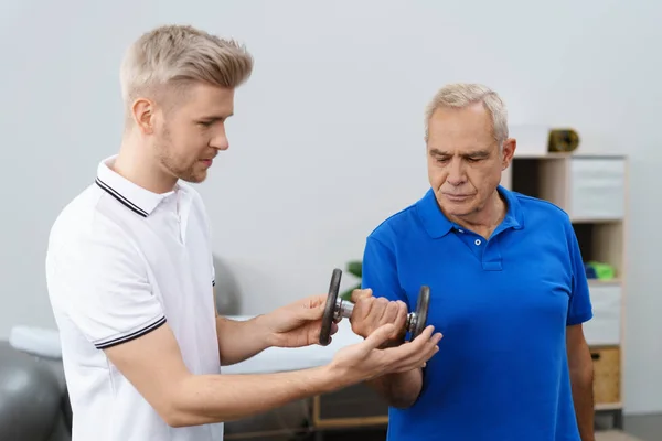 Hombre mayor haciendo ejercicio con entrenador — Foto de Stock