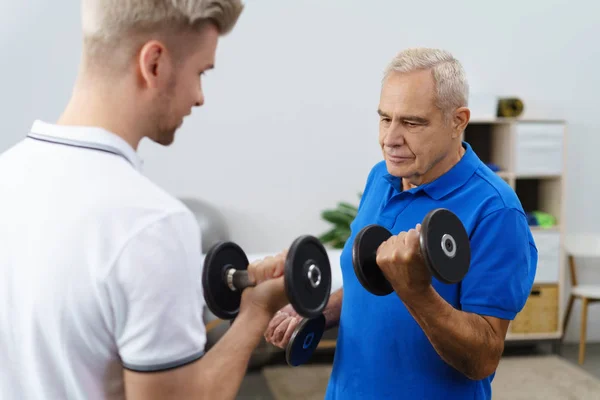 Hombre mayor haciendo ejercicio con entrenador —  Fotos de Stock