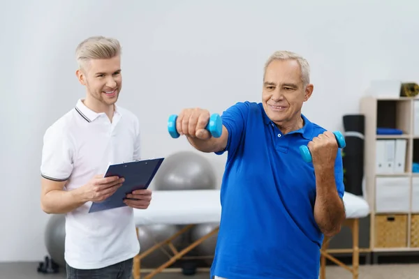 Homem sênior trabalhando com treinador — Fotografia de Stock