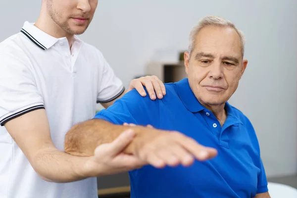 Senior man receiving treatment of shoulder — Stock Photo, Image