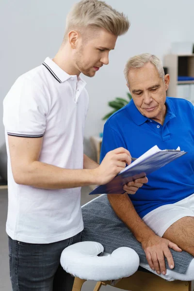 Terapeuta, wyjaśniając wyniki do starszego mężczyzny — Zdjęcie stockowe