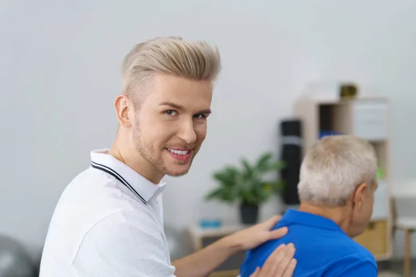 Physiotherapeut blickt lächelnd zurück — Stockfoto