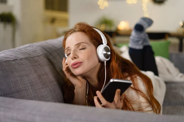 Mulher desfrutando de música com os olhos fechados — Fotografia de Stock