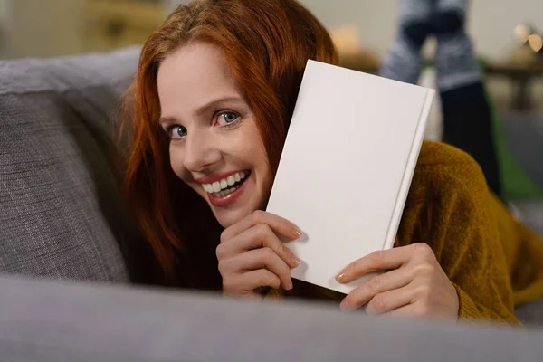 Smiling woman presenting book — Stock Photo, Image