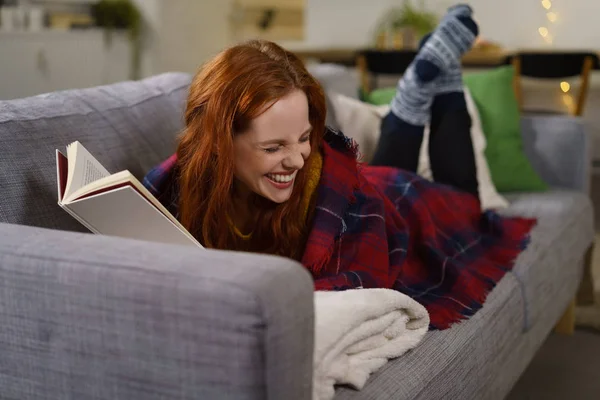읽는 동안 웃 고 하는 여자 — 스톡 사진