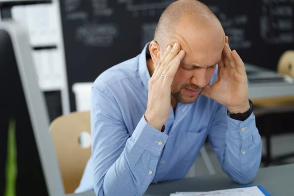 Businessman with headache at office