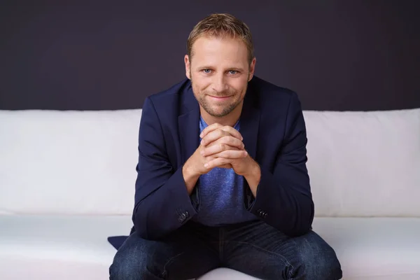 Smiling businessman sitting on sofa — Stock Photo, Image