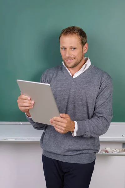 Jonge man staande onderwijs met een tablet — Stockfoto