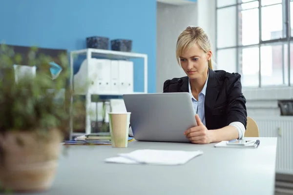 Empresária sentada trabalhando em um laptop — Fotografia de Stock
