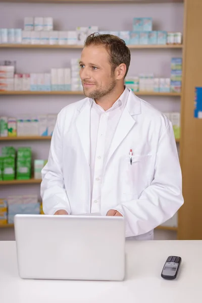 Farmacêutico masculino de pé assistindo alguém — Fotografia de Stock