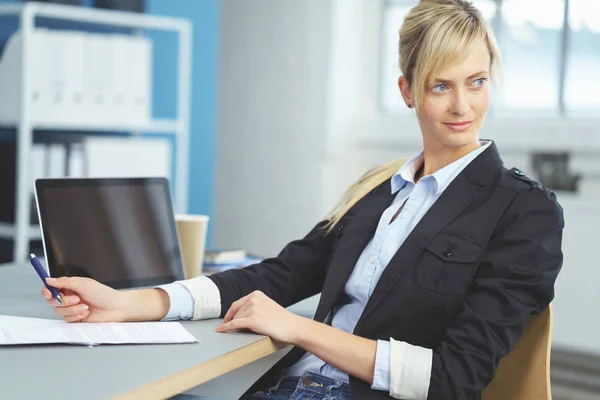 Жінка сидить за своїм столом в офісі, повертаючись — стокове фото